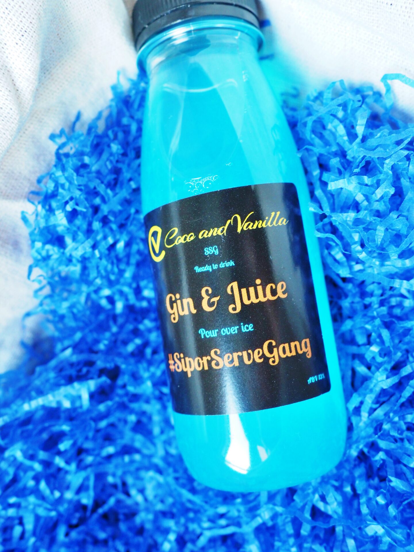 A blue paper background with a bottle of blue raspberry cocktail