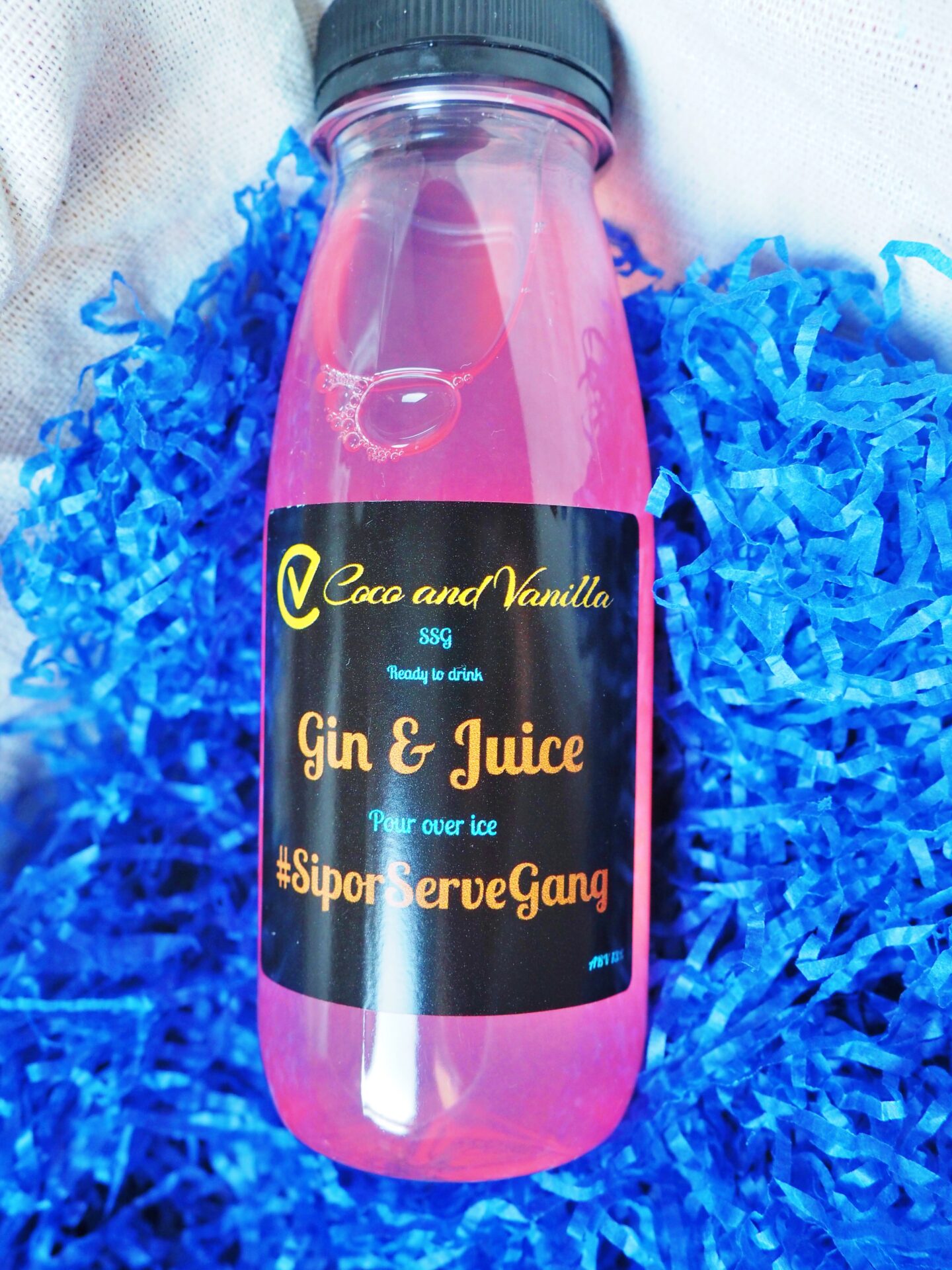 A blue background, with a bottle containing a pink cocktail