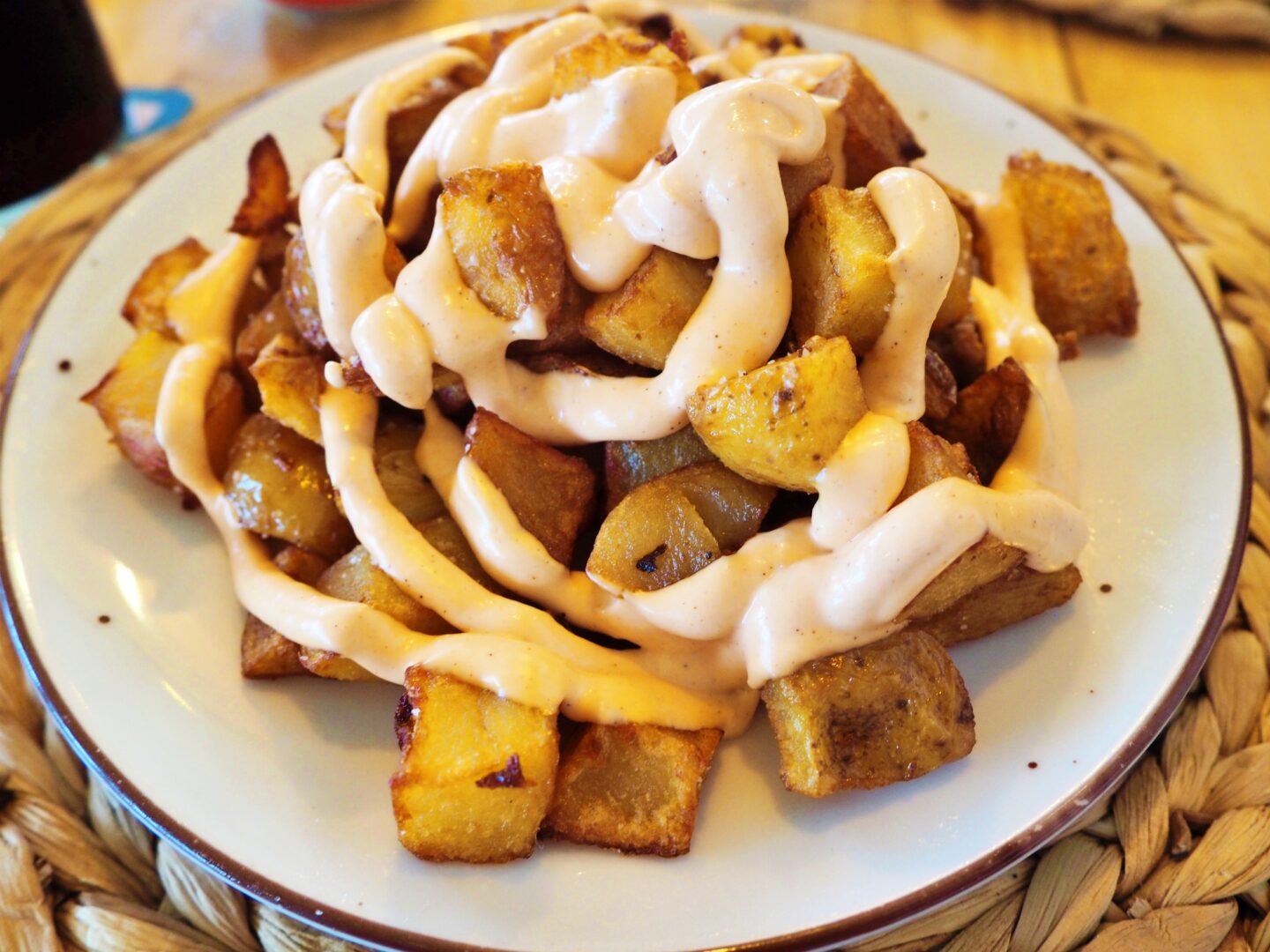 Fried potatoes and spicy mayo on a plate (patatas bravas)