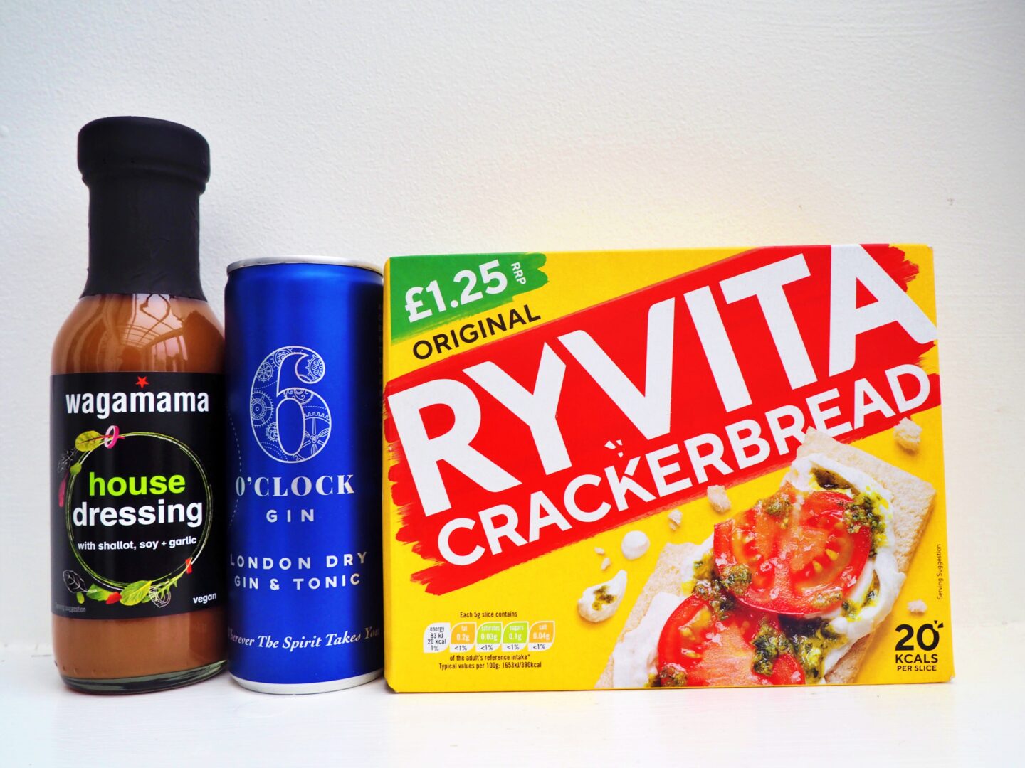 From left to right, wagamama house dressing in a bottle, a can of 6 O'clock Gin and a box of Ryvita crackerbreads.