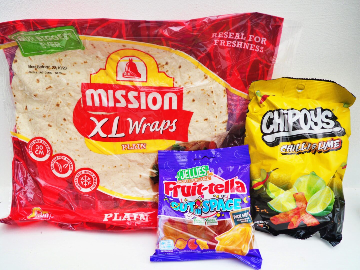 From left to right, Mission Plain XL Wraps in a packet, a packet of Fruit-tella Out In Space Jelly Sweets and a packet of Chipoys Chilli and Lime tortilla chips.