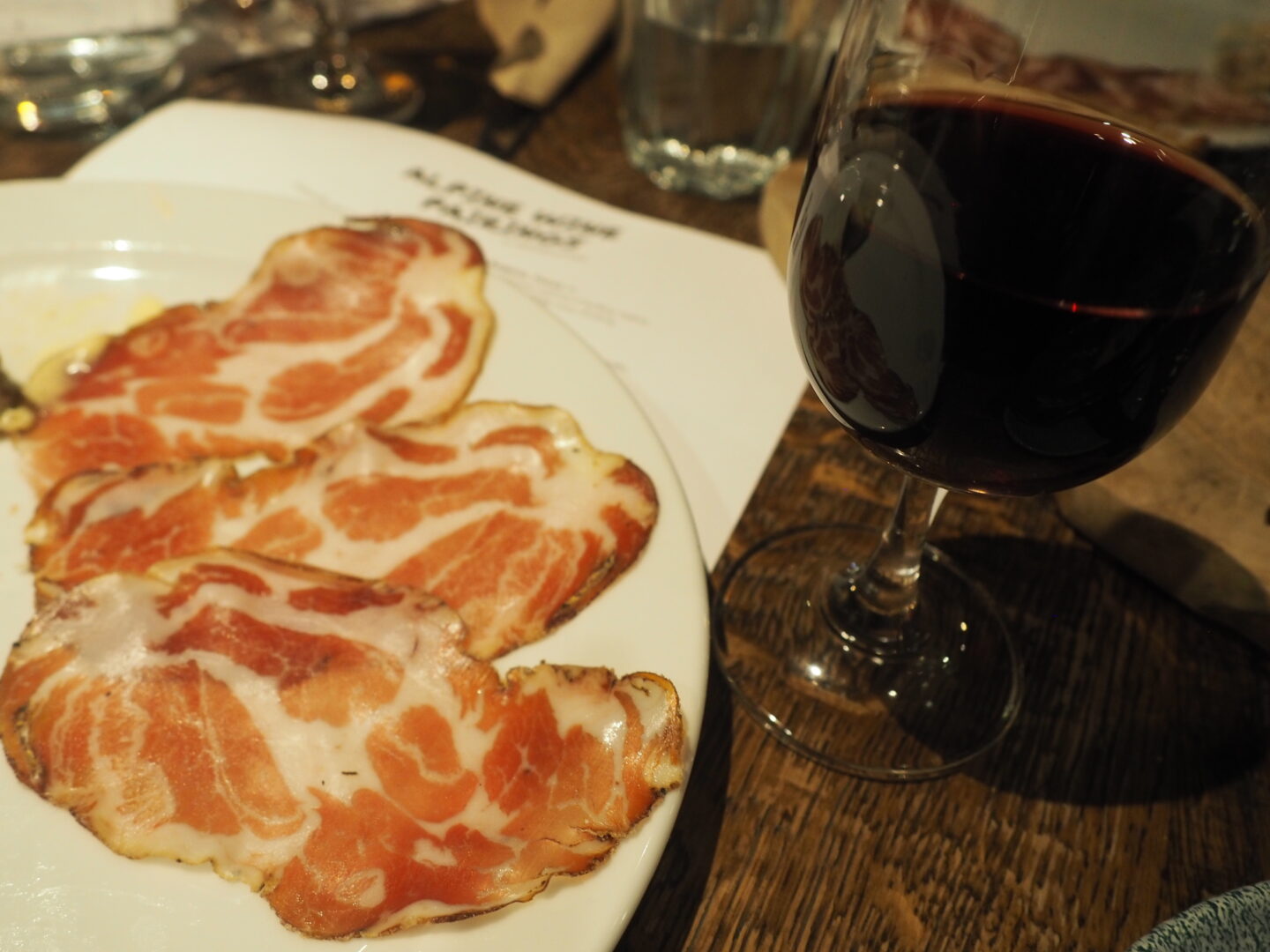 The fourth wine was Martedi Paestum Rosso, Vigneti Tardis, from Campania, Italy, which is a red wine. Next to it is a plate of meat, which it was paired with.