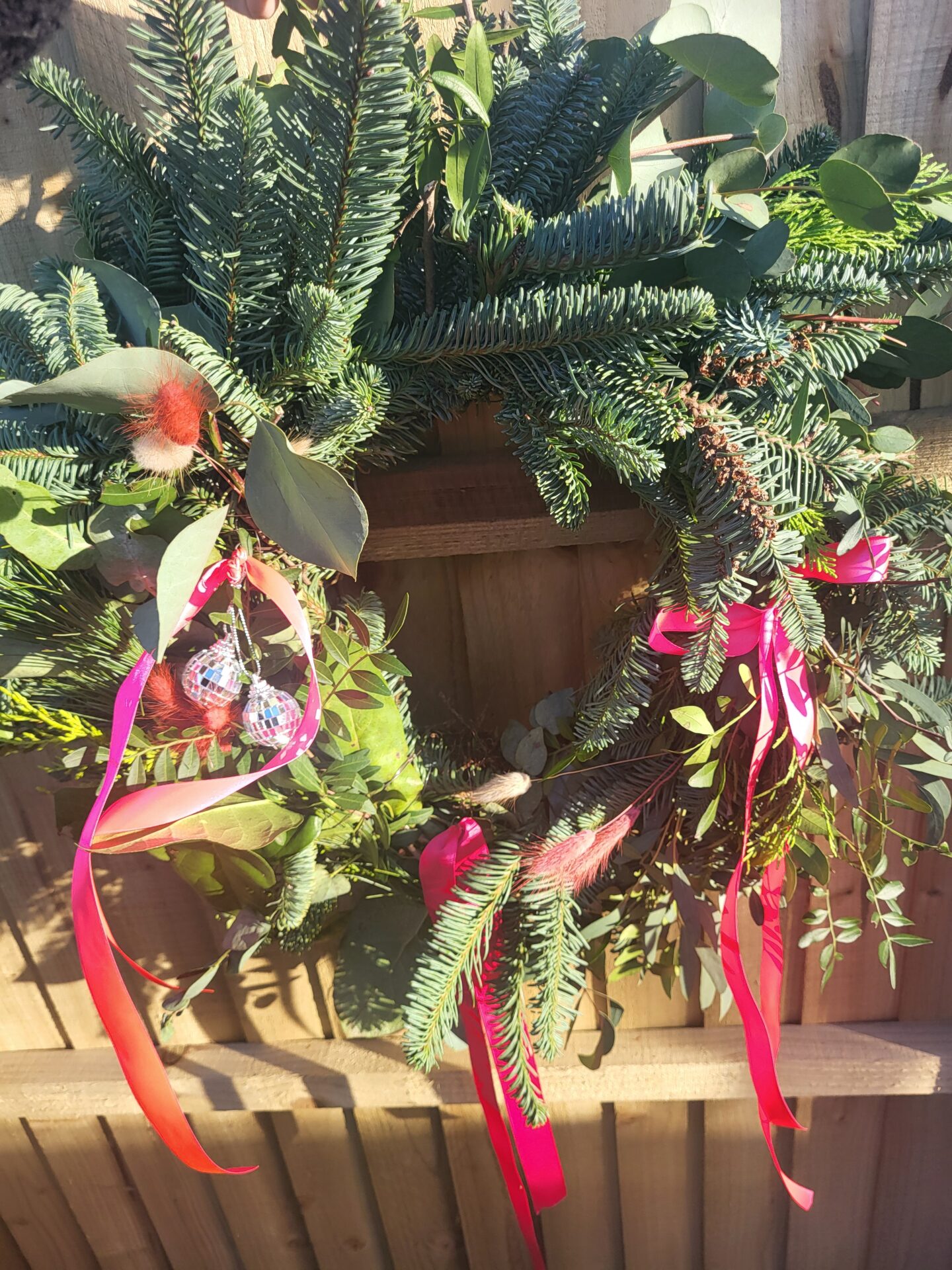 The wreath I made during the wreath making workshop, which I decorated with pink ribbons, dry pink flowers and disco balls.